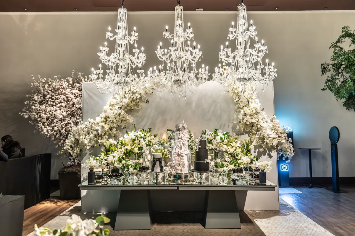 An elegant wedding reception hall dressed with floral installations and soft lighting.