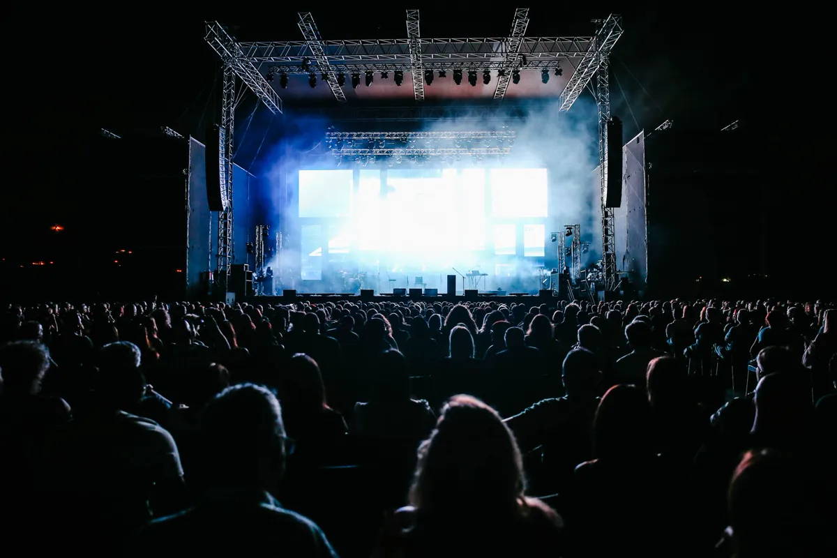 A large live audience lit by stage lights at an entertainment production