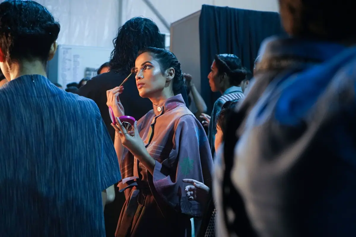 A performer having makeup applied backstage before going on.