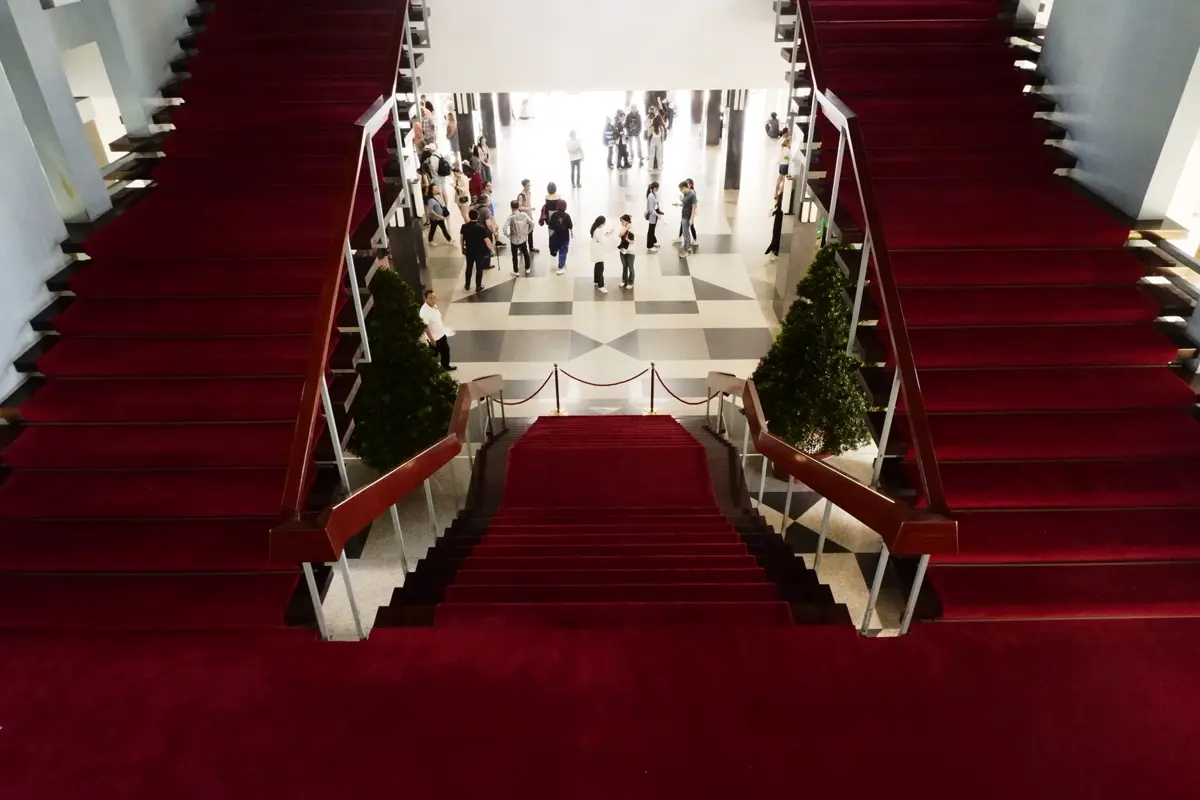 A red-carpeted grand staircase leading up to an event reception